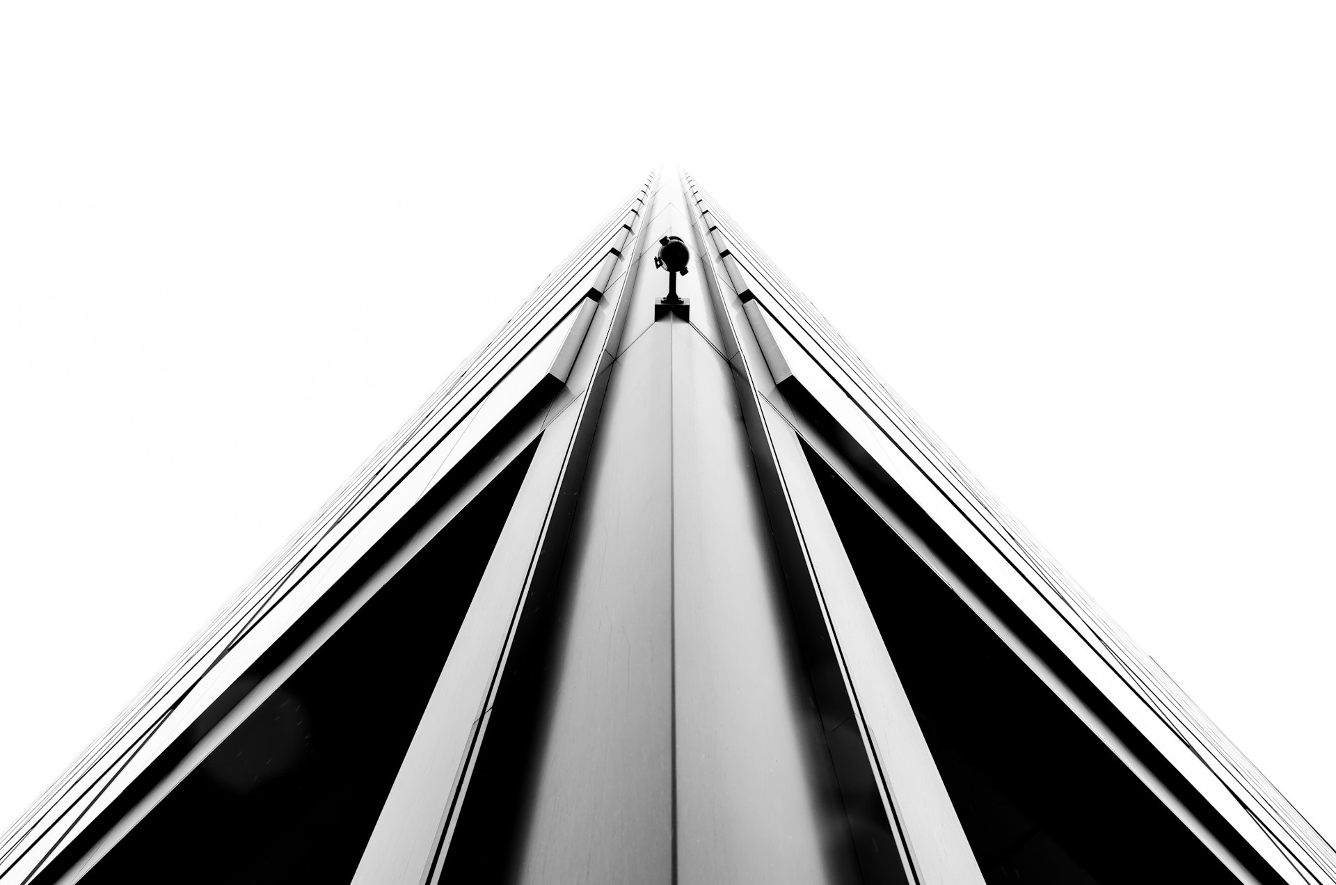 A monochrome shot of a sharp edge on a corner of a tall building